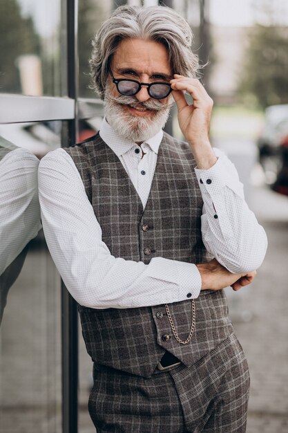 Hombre de negocios guapo parado afuera y pensando