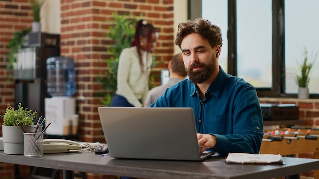 Hombre de negocios hablando en una reunión de videollamada en línea con cámara web, usando chat de teleconferencia remota para reunirse con colegas en Internet. Charlando en videoconferencia, teletrabajo con laptop.