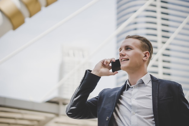 Hombre de negocios hablando por teléfono celular cerca del centro de negocios