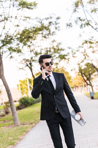 Hombre de negocios hablando por teléfono en el parque