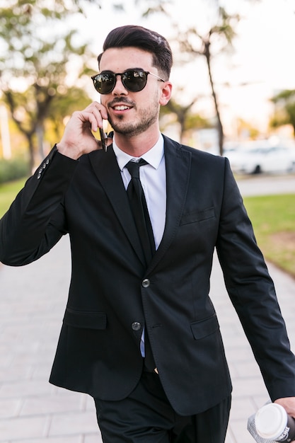 Foto gratuita hombre de negocios hablando por teléfono en el parque