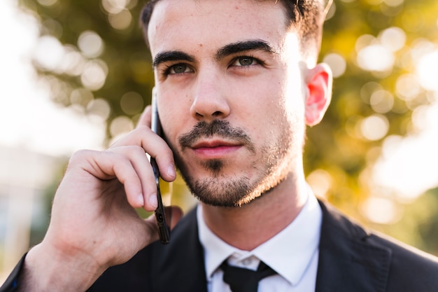 Hombre de negocios hablando por teléfono en el parque