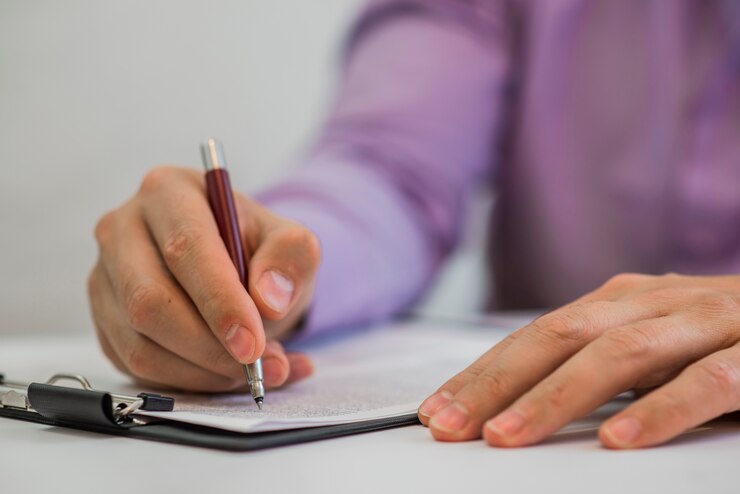 Hombre de negocios haciendo notas en el papel en su oficina