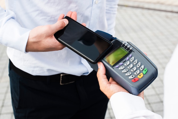 Hombre de negocios haciendo un pago por teléfono