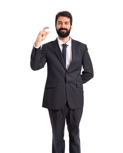 Hombre de negocios haciendo pequeño signo sobre fondo blanco