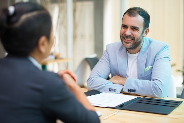 Hombre de negocios hispano positivo escuchando colega