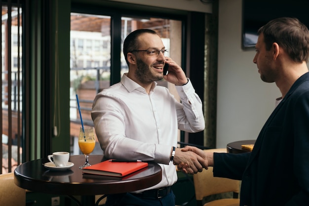 Hombre de negocios con hombre de saludo de smartphone