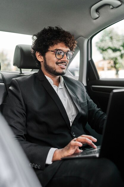 Hombre de negocios indio en el asiento trasero.