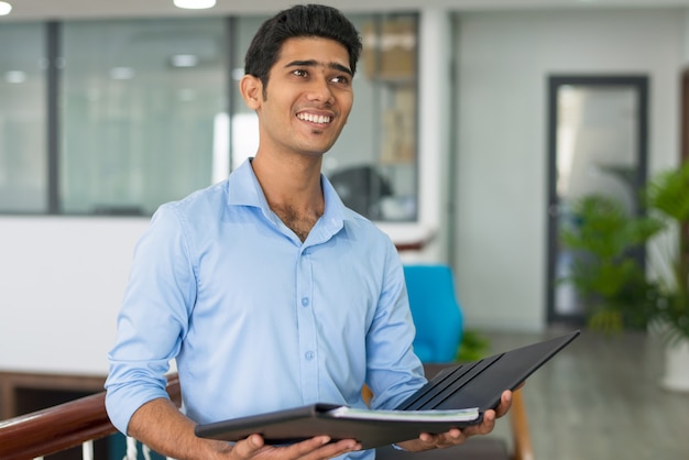 Hombre de negocios indio guapo alegre con documentos