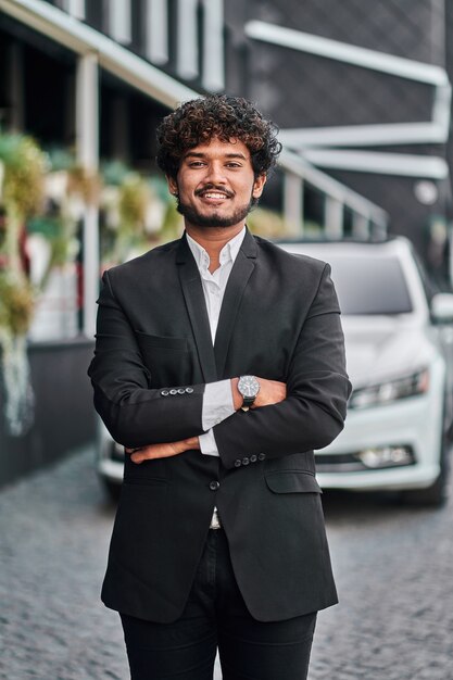 Hombre de negocios indio con su coche blanco.