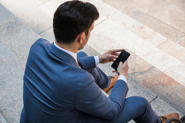 Hombre de negocios irreconocible con smartphone