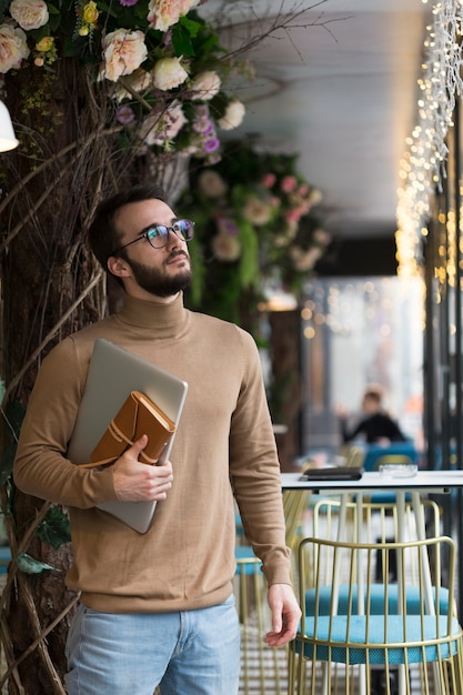 Foto gratuita hombre de negocios joven de alto ángulo con laptop y agenda