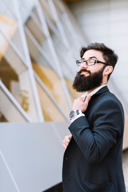 Hombre de negocios joven elegante con la barba negra y el bigote