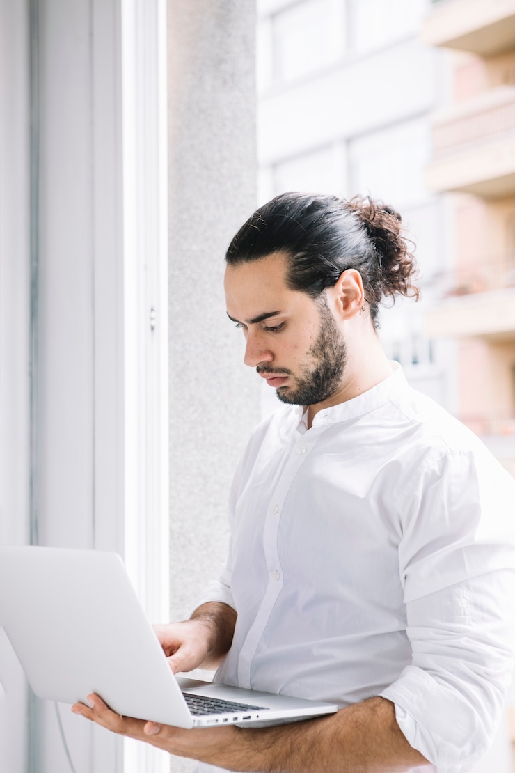 Foto gratuito hombre de negocios joven con estilo que usa la computadora portátil