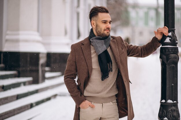Hombre de negocios joven hermoso afuera en invierno