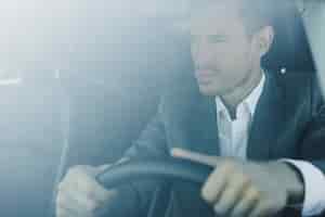 Foto gratuita hombre de negocios joven inteligente conduciendo el coche