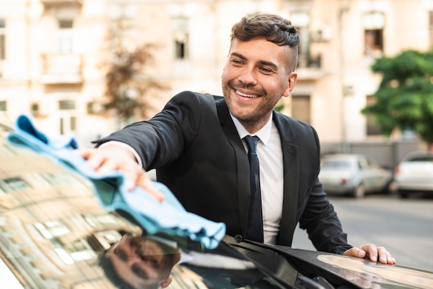 Hombre de negocios joven limpiando el coche