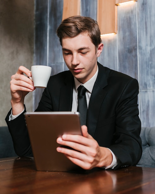 Hombre de negocios joven que mira la tableta