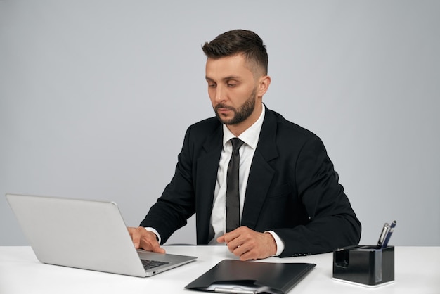 Hombre de negocios joven que trabaja en la computadora portátil
