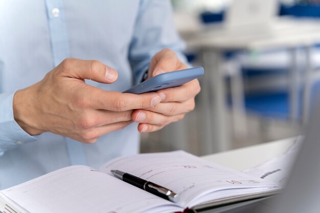 Hombre de negocios joven que trabaja en su escritorio con smartphone