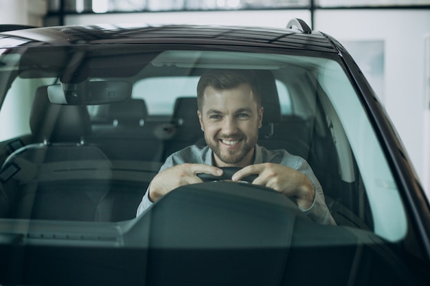 Hombre de negocios joven sentado en un coche