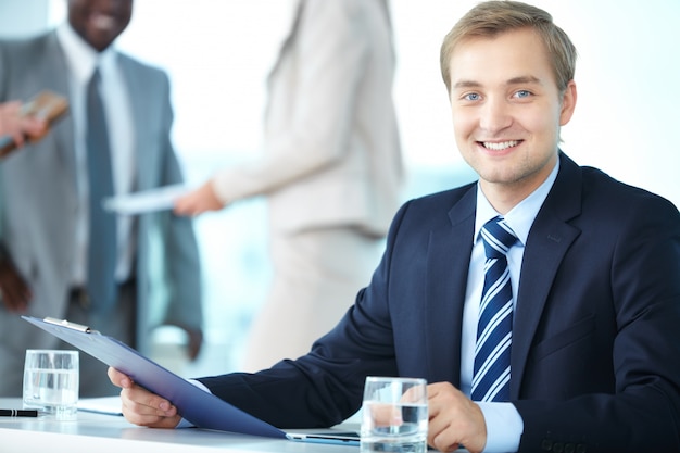 Foto gratuita hombre de negocios joven con un sujetapapeles