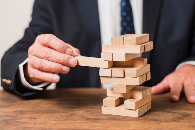 Foto gratuito un hombre de negocios jugando al jenga.