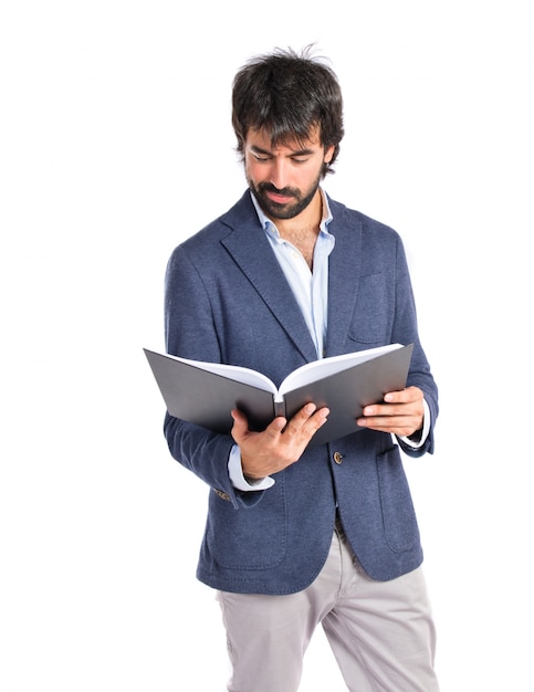 Hombre de negocios leyendo un libro sobre fondo blanco