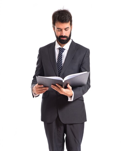 Hombre de negocios leyendo un libro sobre fondo blanco