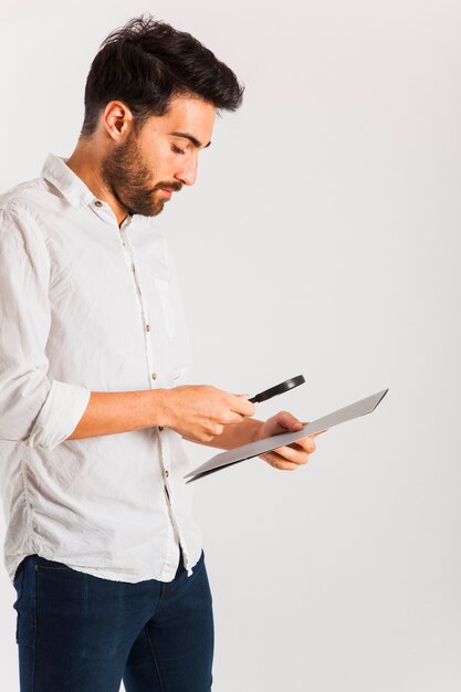 Hombre de negocios leyendo con una lupa