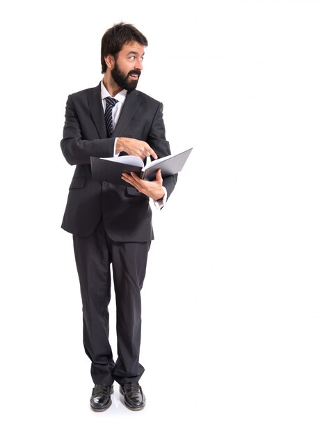 Hombre de negocios con el libro sobre fondo blanco