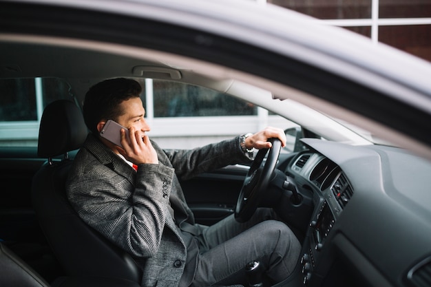 Foto gratuita hombre de negocios llamando dentro de un coche