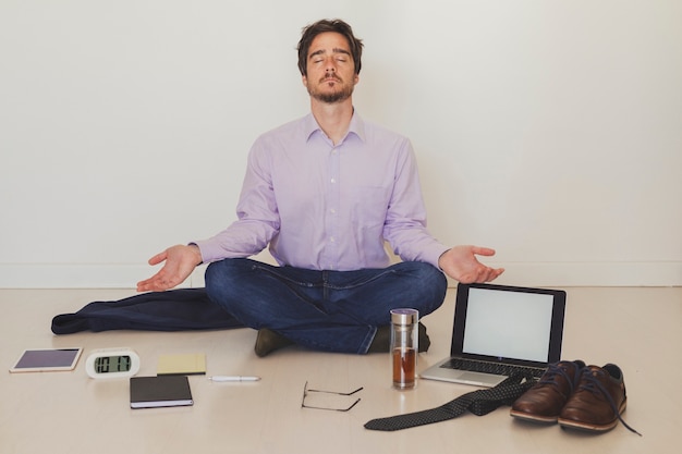 Foto gratuita hombre de negocios meditando en el piso