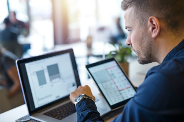 Hombre de negocios mirando y analizando proyectos en su computadora portátil y tableta