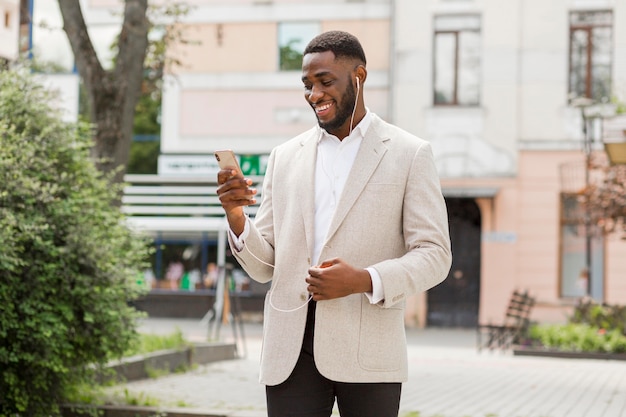 Foto gratuita hombre de negocios, mirar, teléfono inteligente