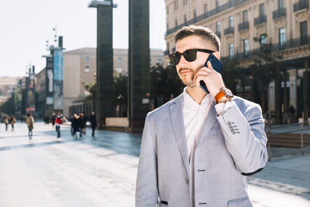 Hombre de negocios moderno haciendo llamada al aire libre