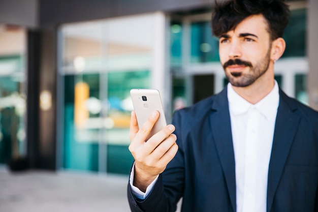 Hombre de negocios moderno mirando a smartphone