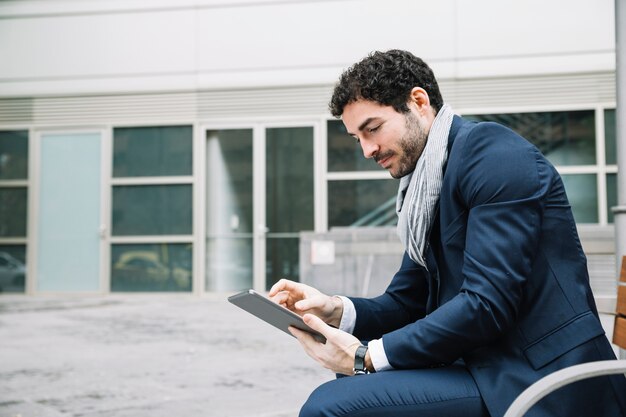 Hombre de negocios moderno usando dispositivo al aire libre