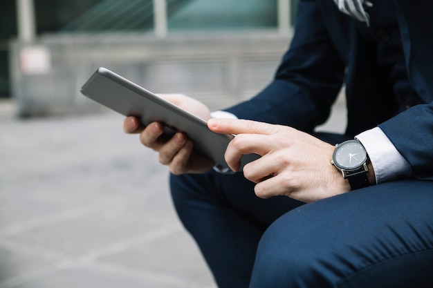 Hombre de negocios moderno usando dispositivo al aire libre