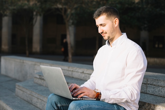 Hombre de negocios moderno usando portátil al aire libre