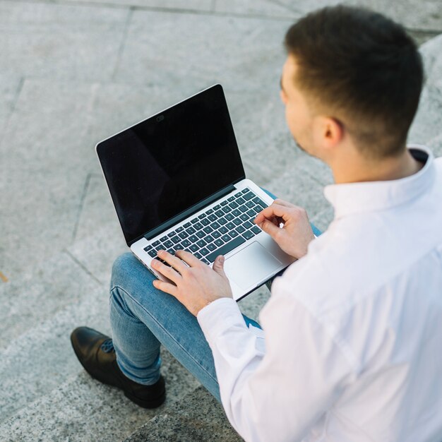 Hombre de negocios moderno usando portátil al aire libre