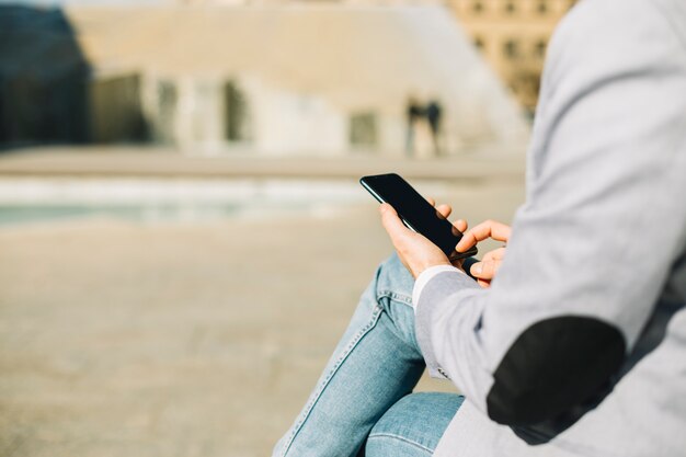 Hombre de negocios moderno usando smartphone al aire libre