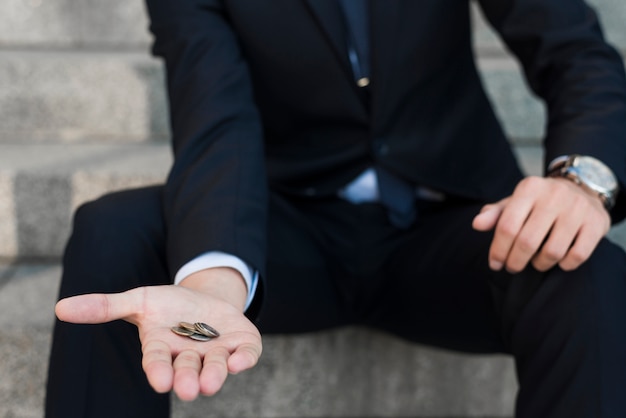 Hombre de negocios con monedas en la mano