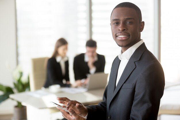 Hombre de negocios negro usando tableta digital en reunión