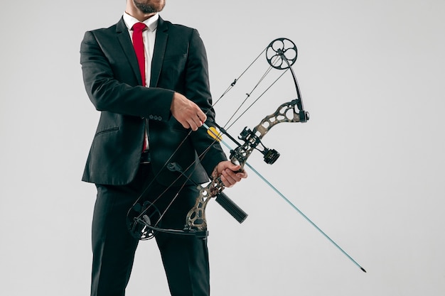 Foto gratuita hombre de negocios con el objetivo de objetivo con arco y flecha, aislado sobre fondo gris.