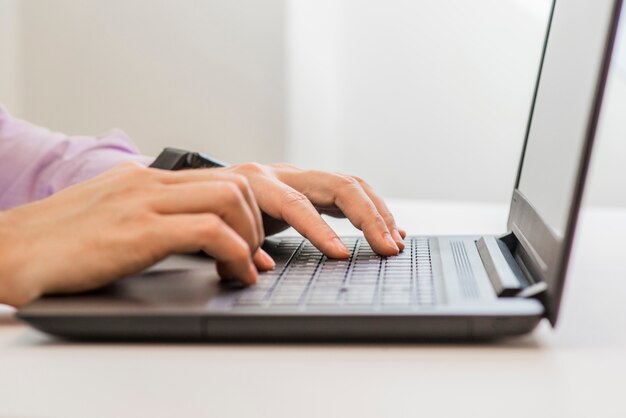 Hombre de negocios con ordenador portátil. Hombre de la mano escribiendo en el teclado del ordenador portátil