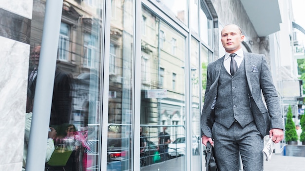 Hombre de negocios pasando por la ventana de vidrio