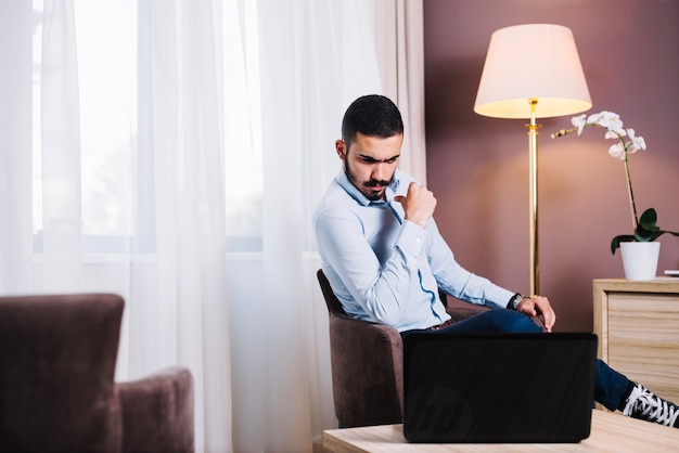 Hombre de negocios pensando en la computadora portátil