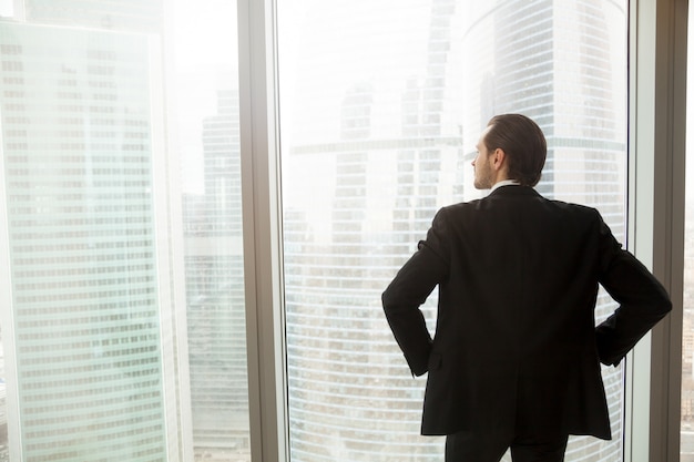 Hombre de negocios pensando en el futuro cerca de la ventana