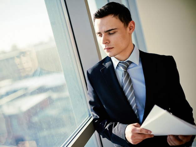 Foto gratuita hombre de negocios pensativo mirando a través de la ventana